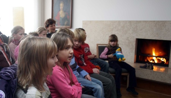 Kinder singen beim Märchenerzähler im Kaminzimmer-gemütlich